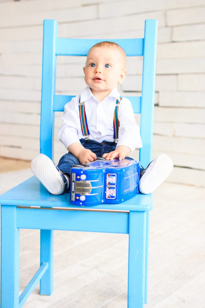 маленький мальчик на стуле в фото студии